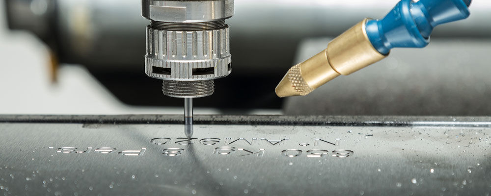 CNC computerized engraver routing out letters into aluminum.